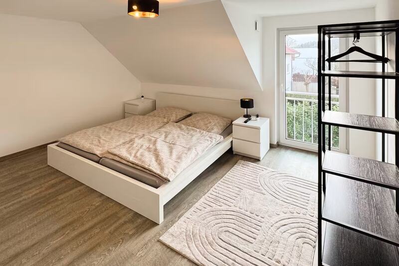 Schlafzimmer mit Kingsize-Doppelbett und Balkontür