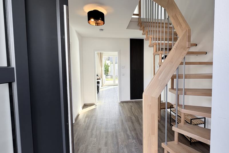 Eingangsbereich mit Holztreppe und Akustik-Lamellen